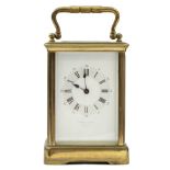 An eight day French brass carriage clock, the white enamel dial with Roman numerals, and inscribed