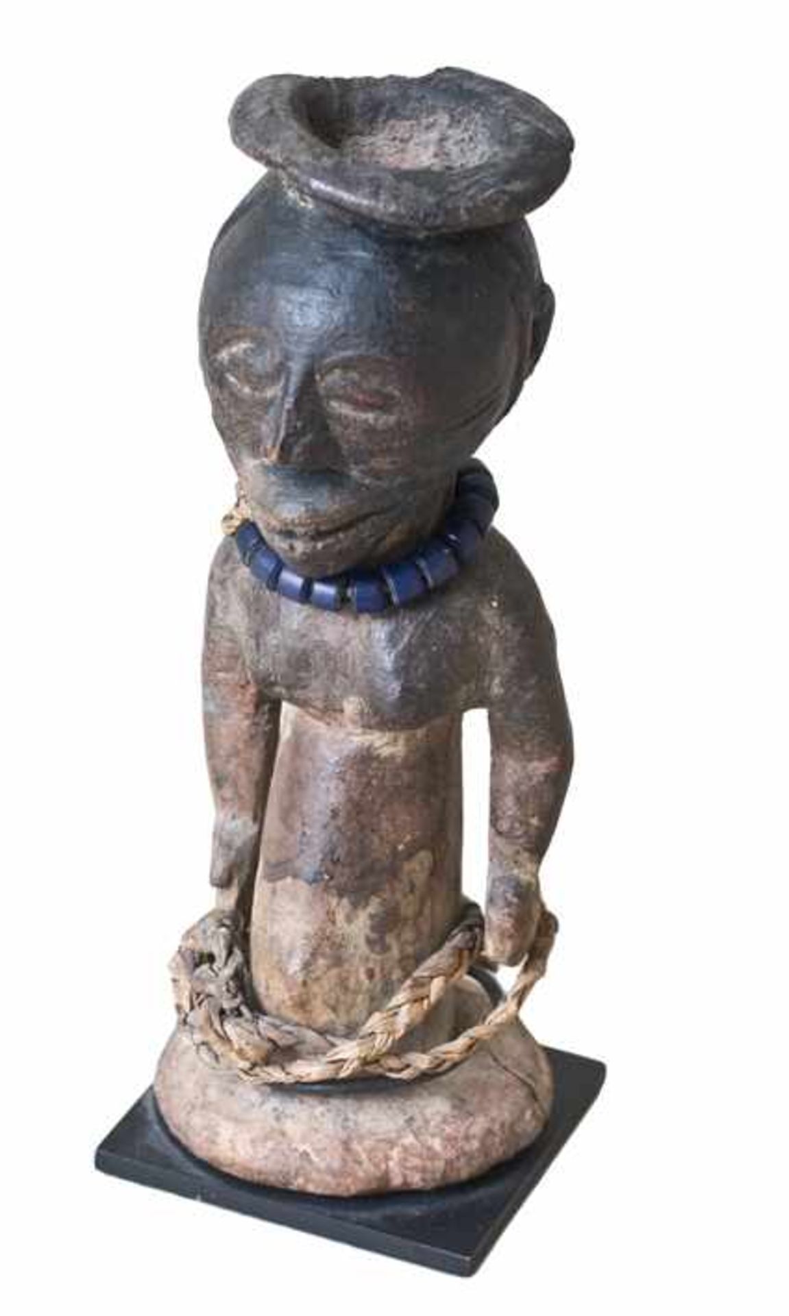 Fetisch-Figur der Kusu aus dunkel gefärbtem Holz mit Bast und Metall. Kongo, 1. Häfte des 20. Jhdts.