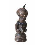 Nkisi. Fetischfigur der Songe aus dunkelbraun gefärbtem Holz mit Hornspitze und Kette. Kongo, 1.