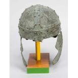 Bronze helmet in ancient manner with side ear angles and neck protection; in the centre visor;