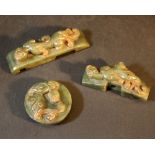 Three jade objects with sculpted dragons and several holes for use, dark green jade with grey