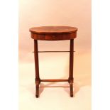 A small Empire mahogany oval table with one drawer, on two round column feet each with two shaped