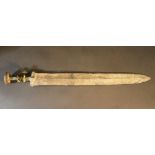 A small bronze sword with handgrip and engraved decorations on the final knob, partly fluted; with