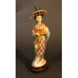A Chinese sculpture of a lady with hat, standing on wooden base; gilded copper with rich