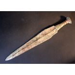 A bronze dagger with spiral hand grip and decorations; thick verdigris; signs of age; possibly
