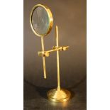 An ophthalmologist magnifyer; on round stand, adjustable in height and distance; glass lense; bronze