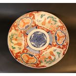 Large Imari dish with blue, red and green painted flowers and decorations; in the three reserves