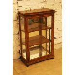 A Biedermeier miniature display cabinet with one door, extened upper border on four small feet,