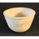 Alabaster bowl with extended rim; possibly Egyptian, late Dynastic period.11,7cm diameter, 7,5cm