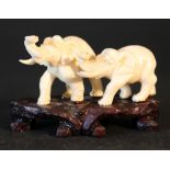 Two Asian ivory elephants on wooden base, naturalistically carved, around 1900.Height 4,3cm,