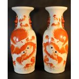 A pair of Chinese red lions vases, with two Fo Lions in red colours; painted on white ground; on the