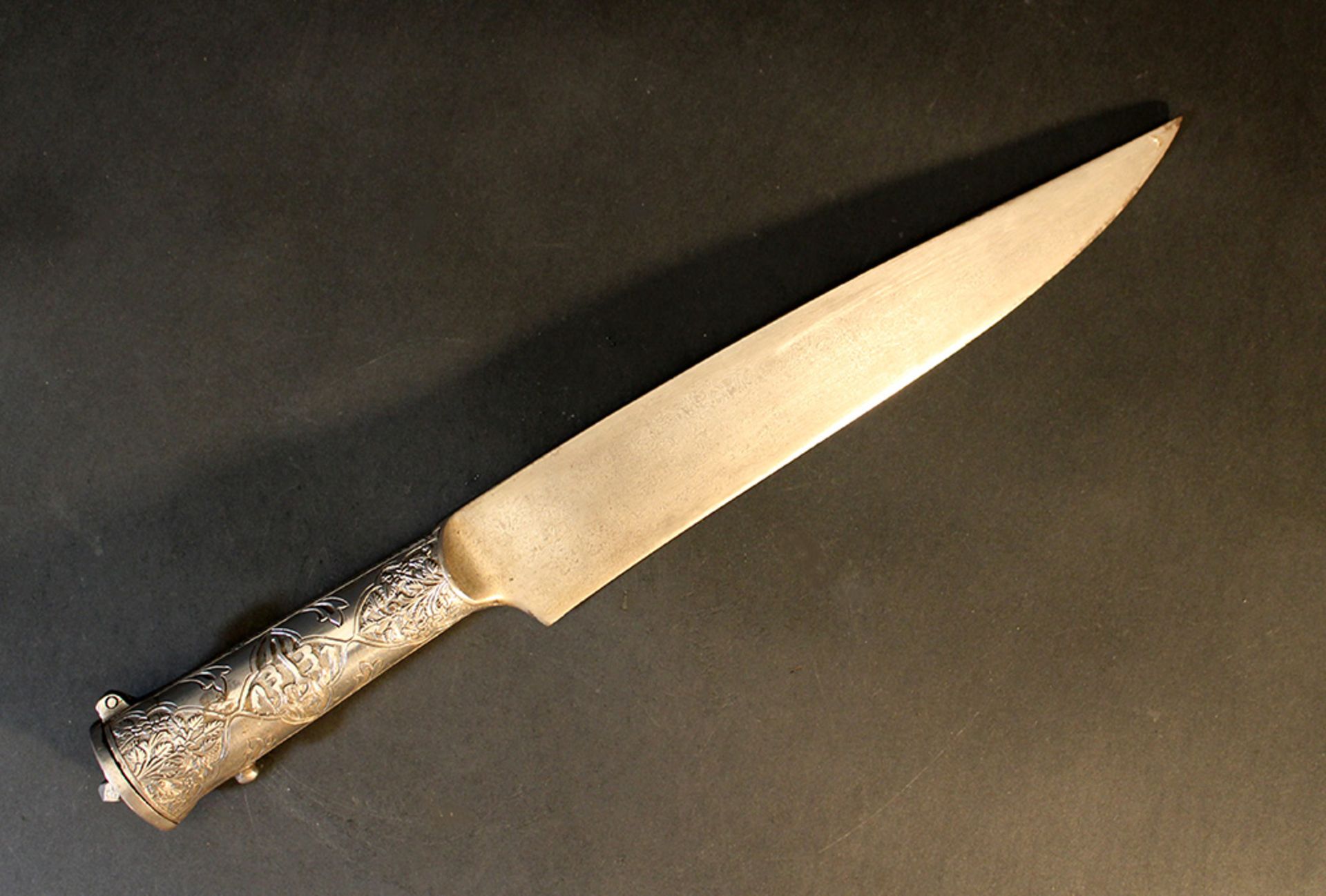 Oriental knife with wide blade and richly decorated steel cutted hand grip with Arabic letters;