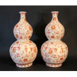 A pair of Chinese pumpkin porcelain vases with long and thiner neck; painted with flowers in