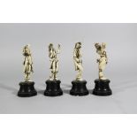 Four ivory figures of funny drinkers, carved on turned wooden ebonised bases, around 1900.height