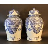 A pair of Chinese porcelain vases with porcelain lids; round bowed shape with small neck; the lids