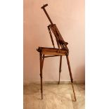 A travel artist's easel, completely collapsible, wood with metal mounts, leather handgrip, described