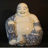 Chinese porcelain Milofo in sitting position with chain in hands; blue painted floral decorations on