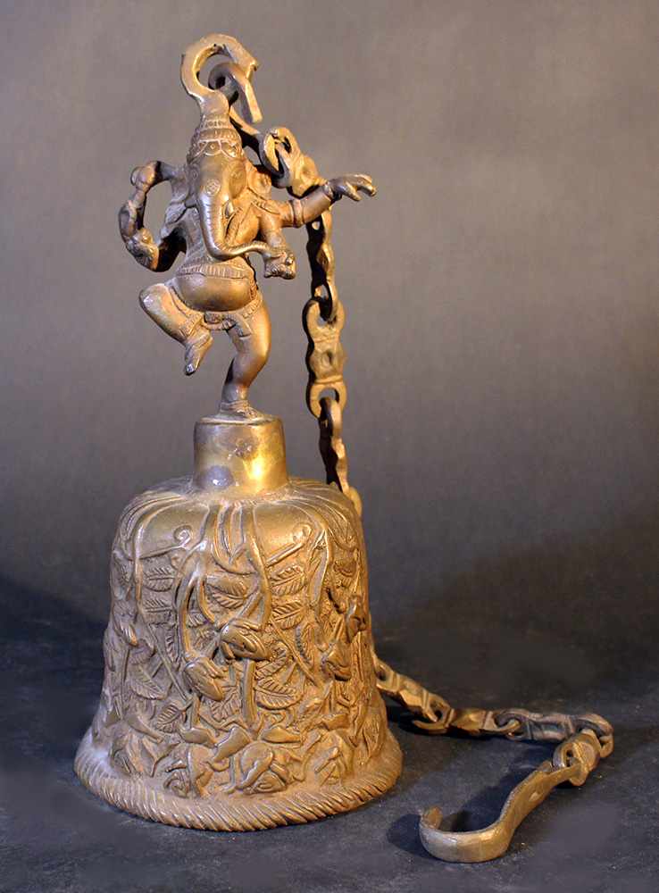 Tibetian metal round bell with dark patina; with floral decorations; on the top a dancing Ganesha