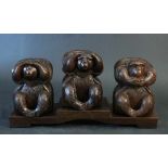 Asian three monkeys group, wood carved on stepped base, 20th Century. length 40cm, height 21cm