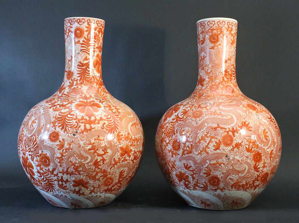 Chinese pair of porcelain vases; white ground with red painting of flowers and dragons; round form