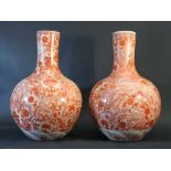 Chinese pair of porcelain vases; white ground with red painting of flowers and dragons; round form