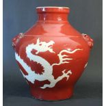 Chinese porcelain vase with red ground and and white dragon, glazed; shaped form with two hand grips