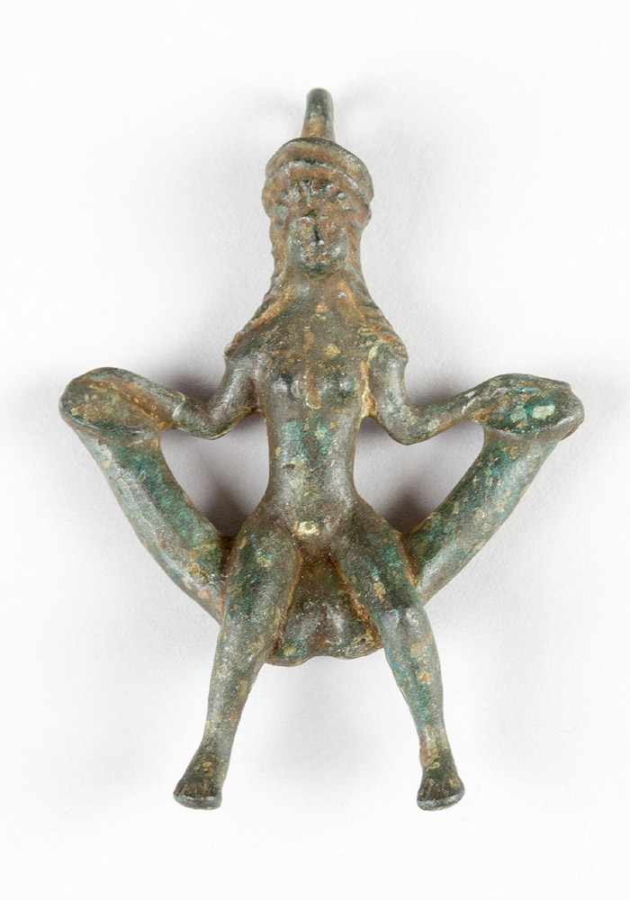 Erotic bronze amulet in Ancient manner shwoing a lady sitting on a bowed seat, on top a ring; full