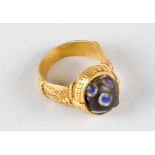An oriental ring of a honorable person with rich figural and ornamental engravings on gilded
