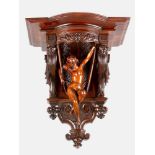 A wooden wall console with rich carvings of a nacked girl on a swing and rich ornamental carved