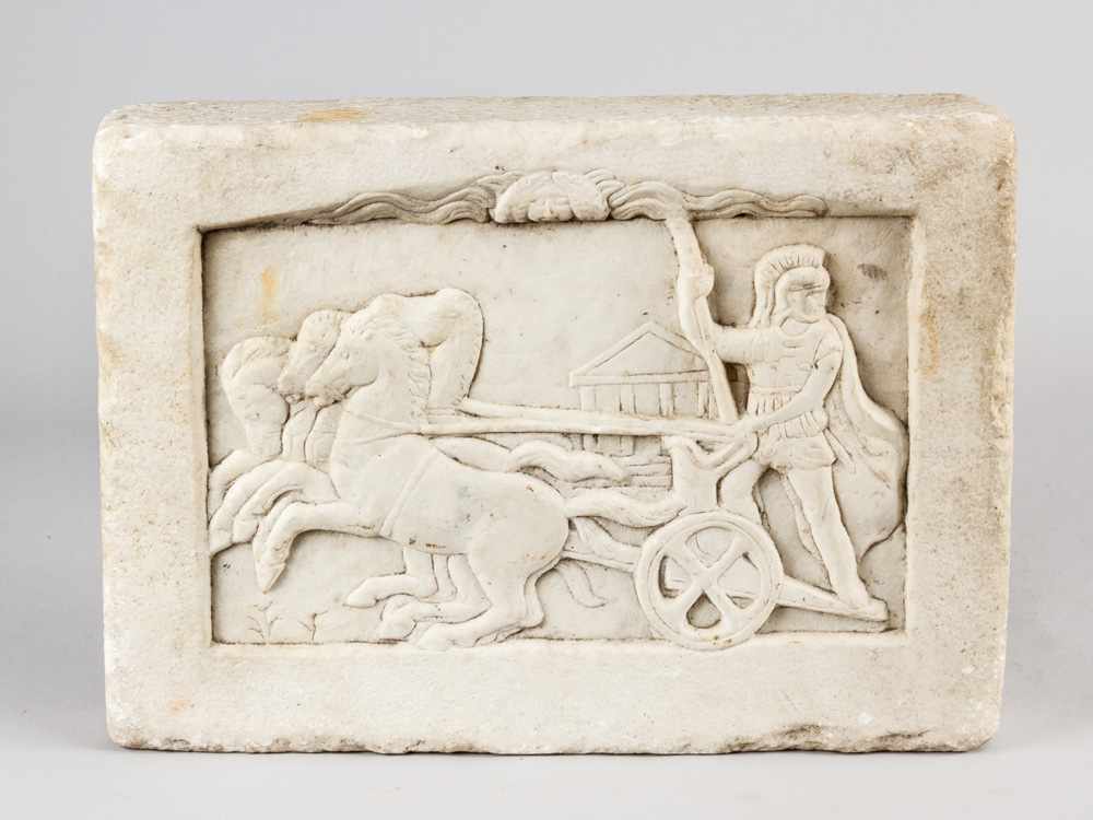 A classical marble relief in rectangular form, with Roman soldier, horses and carriage in front of a