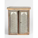 A model of an Indian armoire with two doors and extended upper frieze; massive wood with very fine