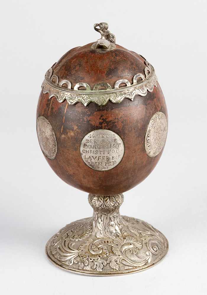 Coconut goblet with rich silver mounts and coins; on central extended foot with floral engraved