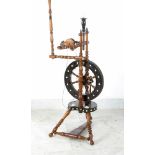 A French ebony and ivory spinning wheel with turned deocrations and brown polished wooden parts;