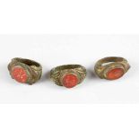 Set of three Roman bronze rings with red gemstones showing a portrait, a centaur and an erotic