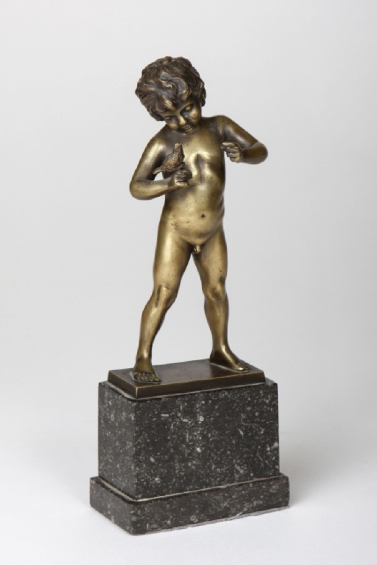 Figur Knabe mit Taube, Gelbmetall, auf Steinsockel montiert, bezeichnet R.W. Höhe ca. 28,5cm;