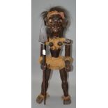 A solid wood Ethnic tribal figure with spear and articulated shoulders. Approx 1 metre tall.