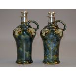 A pair of Royal Doulton silver mounted wine flagons with Art Nouveau decoration & green/grey glaze,