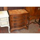 A reproduction mahogany serpentine fronted small chest of 4 drawers with brushing slide