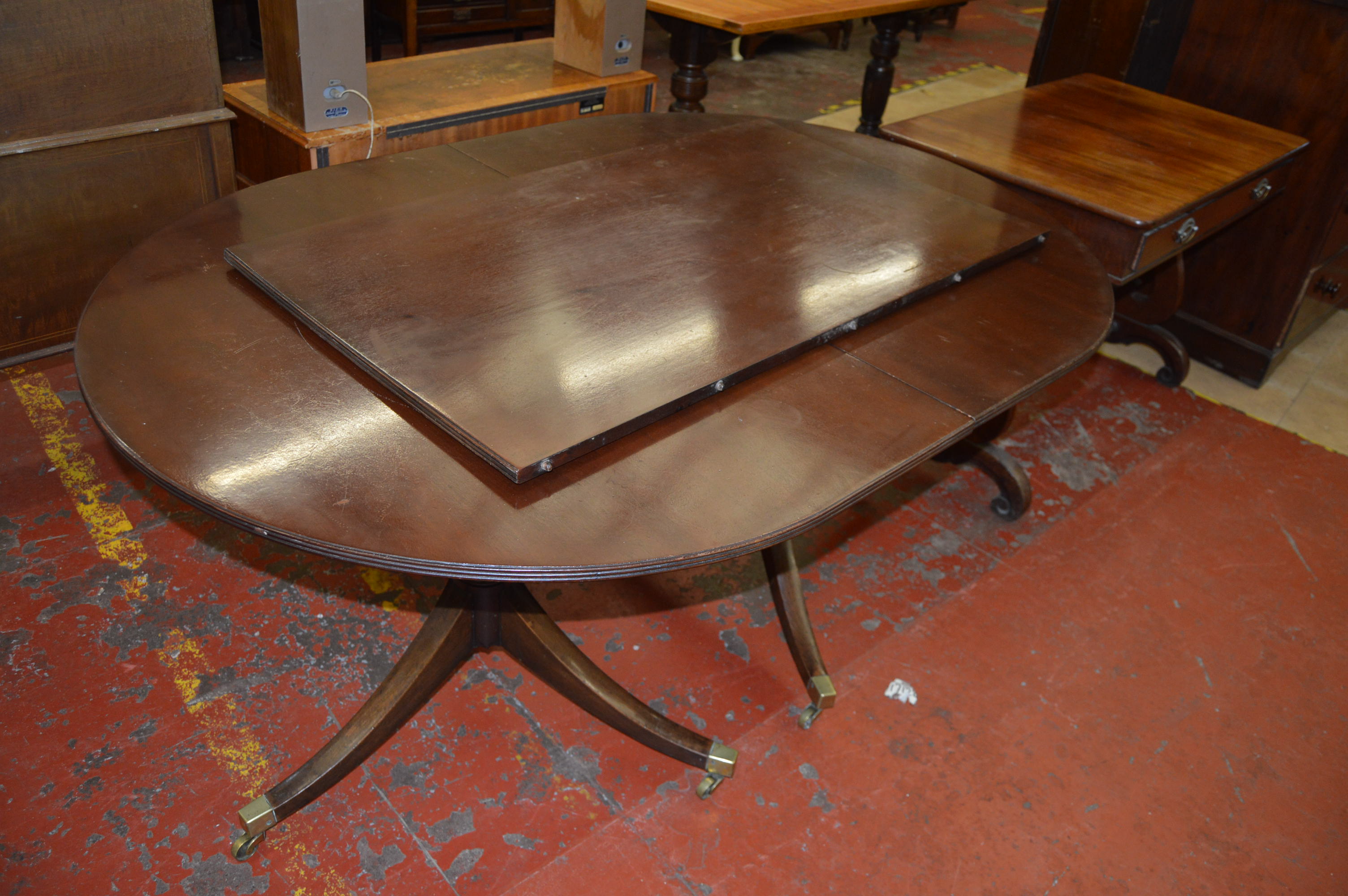 A reproduction mahogany dining table in regency style