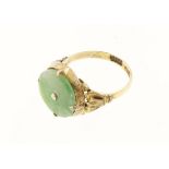 An oriental jade & yellow metal ring set with central round disc, indistinct marks, approx 3.