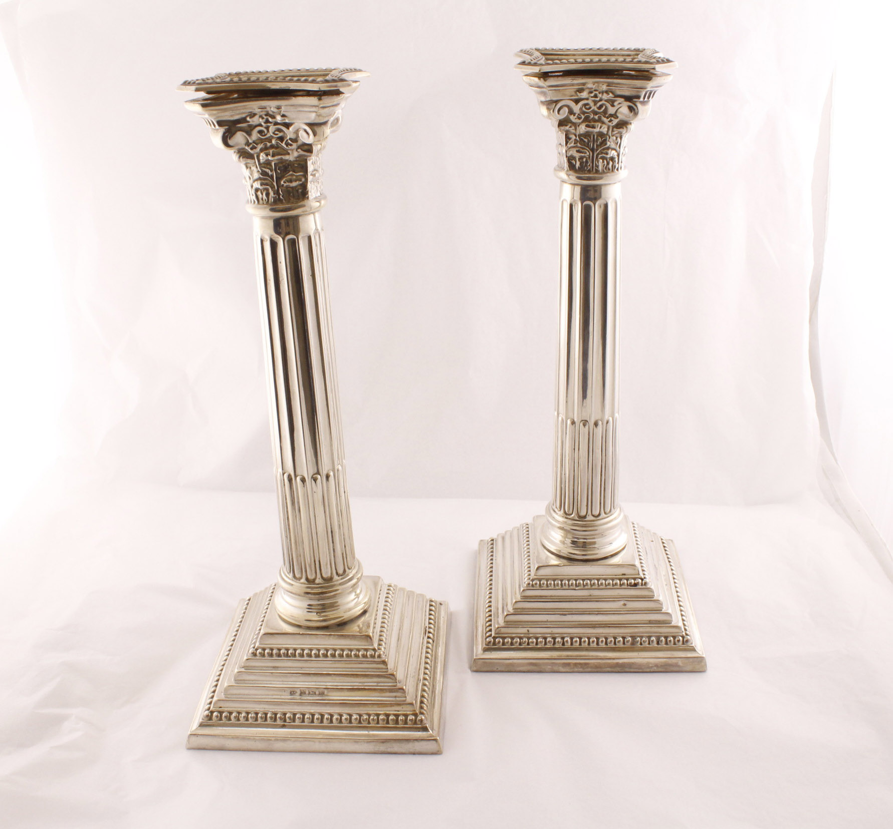 A pair of silver Corinthian column candlesticks with sconces, 250mm high & filled,