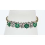 An 18ct H/M emerald and diamond 7 stone ring, approx total diamond weight 0.