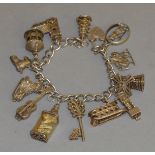 A silver charm bracelet with various charms including one hallmarked silver example