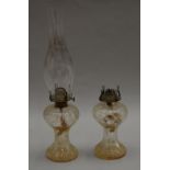 A pair of clear glass oil lamps. 22cm tall without chimney.