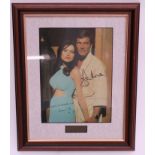 Roger Moore autograph and Madeline Smith autograph on a colour photo together in a scene from the