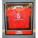 A framed Manchester United FC squad home shirt signed by the Manchester United Squad,