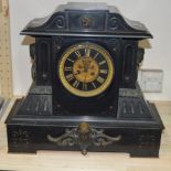 A large slate mantle clock with gilt dial with Roman numerals.