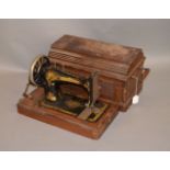 A late Victorian Singer sewing machine in wooden case.