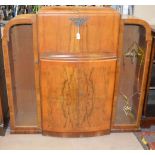 A 1950s burr walnut veneered cocktail cabinet with flanking show cases. Keys included.