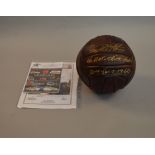 A vintage football signed by Sir Geoff Hurst in gold marker pen.